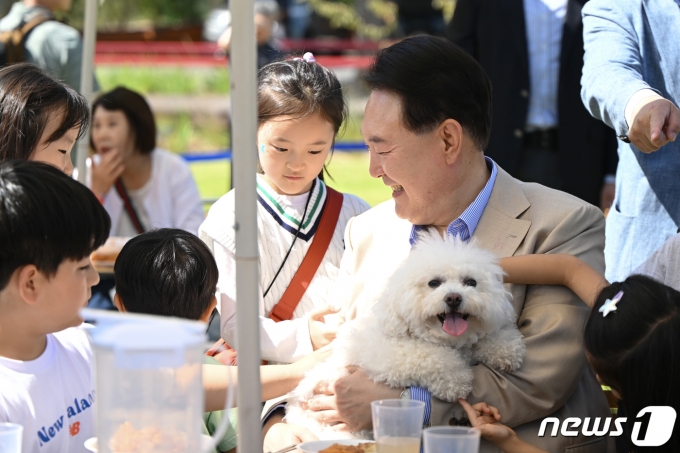 윤석열 대통령이 24일 서울 용산어린이정원에서 열린 추석맞이 팔도장터를 깜짝 방문해 반려견 써니를 안은 채 어린이들과 대화하고 있다. (대통령실 제공) 2023.9.24/뉴스1 ⓒ News1 오대일 기자