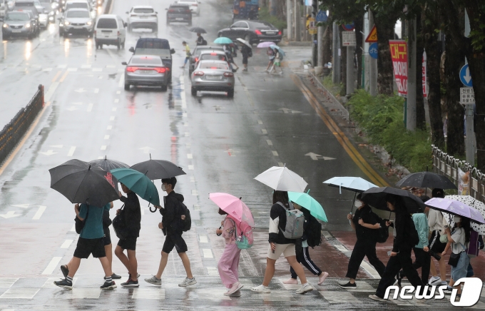 가을비가 내리는 21일 오후 대구 북구 한 초등학교 앞에서 하굣길 우산을 쓴 학생들이 횡단보도를 건너고 있다. 2023.9.21/뉴스1 ⓒ News1 공정식 기자