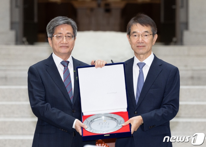 김명수 대법원장(왼쪽)이 22일 오전 서울 서초구 대법원에서 열린 퇴임식에서 안철상 대법관에게 감사패를 전달 받은 후 기념 촬영을 하고 있다. 2023.9.22/뉴스1 ⓒ News1 이재명 기자