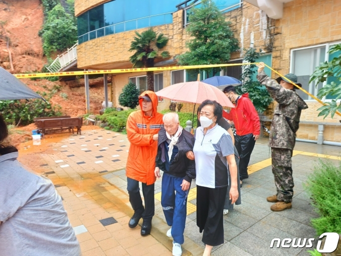 지난 7월16일 전남 여수시 돌산읍 한 요양병원 뒷산에서 토사가 쏟아져 환자 등이 대피하는 모습. (전남소방본부 제공)
