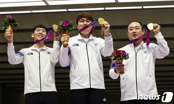 곽용빈(왼쪽부터), 정유진, 하광철이 26일 중국 항저우 푸양 인후 스포츠센터에서 열린 2022 항저우 아시안게임 사격 남자 10m 러닝타깃 혼합 단체전 시상식에서 금메달을 들고 포즈를 취하고 있다. 2023.9.26/뉴스1 ⓒ News1 유승관 기자