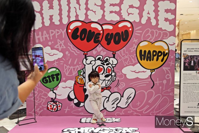 광주신세계 1층에 조성된 지역작가 협업 아트월(ART WALL) 프로젝트 포토존에서 아이가 포즈를 취하고 있다/사진=광주신세계 제공.
