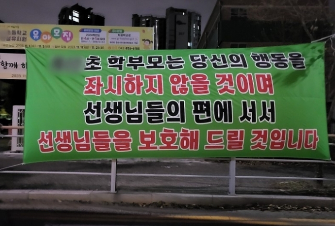 대전에서 악성 민원으로 교사를 숨지게 한 학부모가 지역 내 다른 동네로 이사했다. 가해자의 자녀가 전학 간 학교의 학부모들은 소식을 전해 듣자 그를 지탄하는 현수막을 내거는 등 단체 행동에 나섰다. /사진=온라인 커뮤니티 캡처
