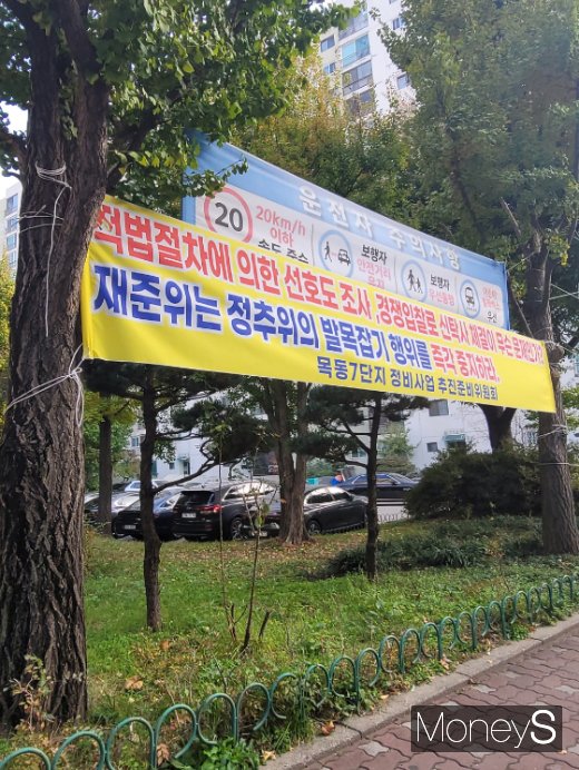  목동7단지 정문으로 들어가니 추진위와 준비위가 각각 걸어놓은 현수막이 눈에 띄었다. 추진위가 걸어놓은 현수막엔 '적법절차에 의한 선호도 조사, 경쟁입찰로 신탁사 체결이 무슨 문제인가? 준비위는 추진위의 발목잡기 행위를 즉각 중지하라'라고 쓰여 있었다. /사진=신유진 기자