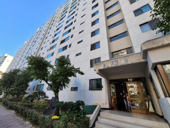 아파트 동 출입구 지붕은 페인트칠이 다 벗겨져 있었고 바깥벽엔 군데군데 금이 가 있었다. /사진=신유진 기자 