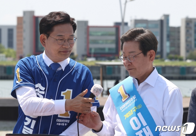 송영길 더불어민주당 서울시장 후보가 지난해 5월27일 김포시 고촌읍 아라 김포여객터미널 아라마린센터 앞 수변광장에서 열린 김포공항 이전 수도권 서부 대개발 정책협약 기자회견에서 이재명 인천 계양을 국회의원 후보에게 마이크를 넘기고 있다./뉴스1 ⓒ News1 국회사진취재단