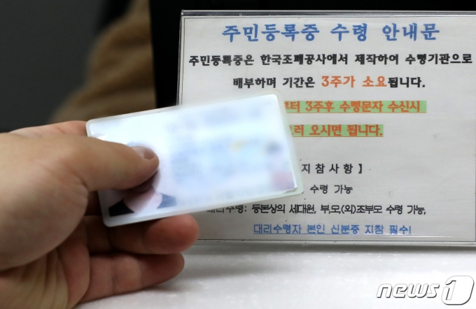 한 주민이 주민등록증을 수령하고 있다. ⓒ News1 이동해 기자
