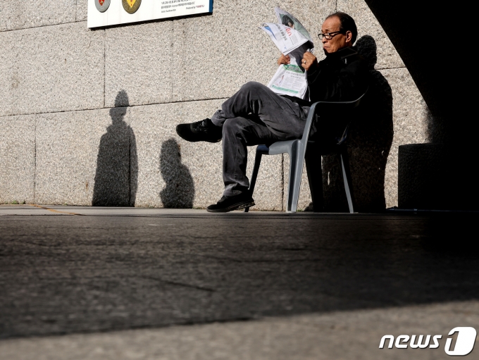 서울의 낮 최고기온이 16도까지 오르며 포근한 날씨를 보인 8일 서울 중구 청계천에서 한 어르신이 가벼운 옷차림으로 신문을 읽고 있다. 2023.12.8/뉴스1 ⓒ News1 이동해 기자