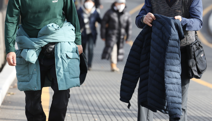 서울 용산구 남산타워를 찾은 시민이 외투를 들고 발걸음을 옮기고 있다./사진=뉴스1