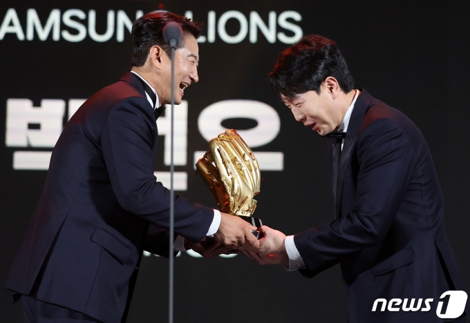 박건우(NC 다이노스)가 11일 오후 서울 강남구 코엑스에서 열린 ‘2023 신한은행 SOL KBO 골든글러브 시상식’에서 외야수 부문 골든글러브에 선정된 뒤 박용택 KBS 해설위원에게 트로피를 받고 있다. 2023.12.11/뉴스1 ⓒ News1 김진환 기자