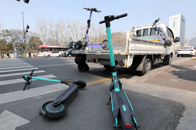 서울광장 앞 횡단보도에서 전동킥보드 견인 업체 관계자가 무단 방치된 전동킥보드 수거 시연을 하고 있다. 사진은 기사 내용과 무관함./사진=뉴스1