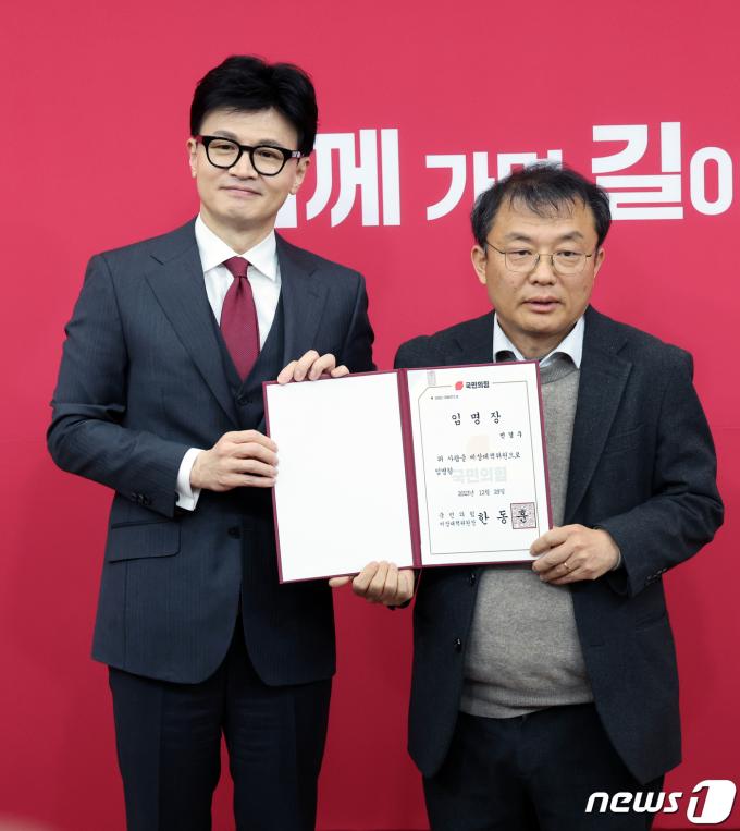 한동훈 국민의힘 비상대책위원장이 29일 오후 서울 여의도 국회에서 열린 비상대책위원 임명장 수여식 및 제1차 비상대책위원회의에서 민경우 비대위원에게 임명장 수여 후 기념촬영을 하고 있다. 2023.12.29/뉴스1 ⓒ News1 황기선 기자