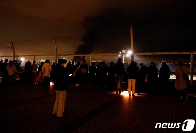 하네다 공항 전망대에서 비행기 충돌 현장을 지켜보고 있는 시민들. ⓒ 로이터=뉴스1 ⓒ News1 박형기 기자