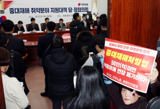 유의동 국민의힘 정책위의장이 지난해 12월27일 오전 서울 여의도 국회에서 열린 중대재해 취약분야 지원대책 관련 당정협의회에서 발언을 하고 있다. 입구에서 강은미 정의당 의원과 고 김용균씨의 어머니 김미숙 김용균재단 이사장 등이 50인(건설업은 공사금액 50억) 미만 적용유예 연장 폐기 피켓시위를 하고 있다. / 사진=뉴시스 조성봉 기자 