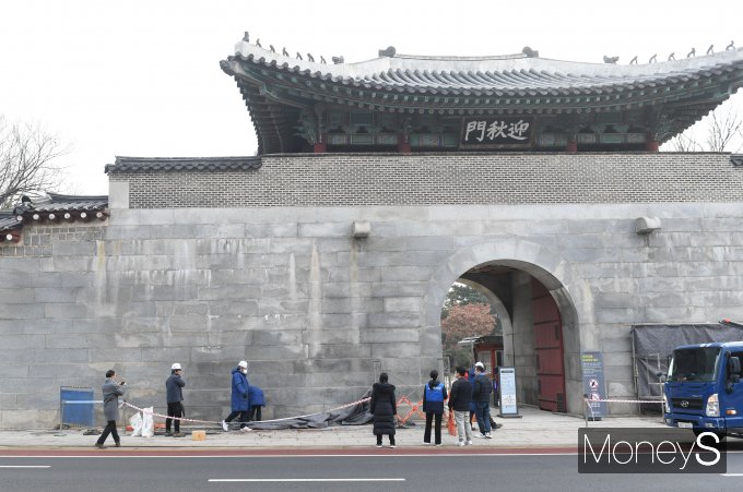 경복궁 담장이 복구 작업을 마치고 공개된 가운데 경복궁과 종묘 등 문화재 주변 CCTV 추가 설치 등 보호 대책이 강화될 예정이다. 사진은 문화재청 관계자들이 4일 오전 서울 종로구 경복궁 영추문과 국립고궁박물관 쪽문 주변에 낙서 복구 작업으로 설치됐던 가림막을 철거하는 모습. /사진=장동규 기자