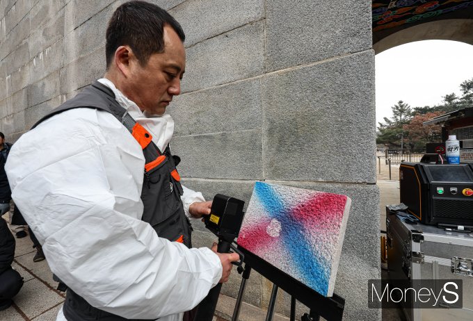 4일 오전 서울 종로구 경복궁 영추문 담장에서 이태종 학예사가 레이저 세척기로 낙서 제거를 시연하고 있다./사진=장동규 기자