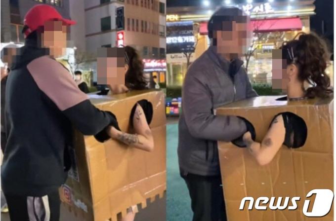 2023년 10월20일 밤 10시 무렵 홍대에  박스만 걸친채 나타나 인플루언서 아인이 지나가는 사람에게 박스안에 손을 넣어 볼 것을 권하고 있다. (SNS 갈무리) ⓒ 뉴스1