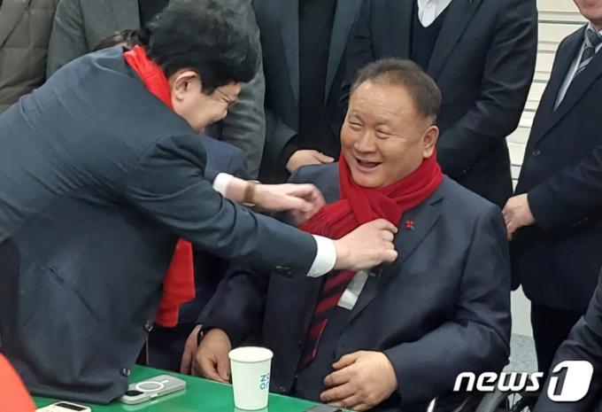 윤창현 국민의힘 국회의원(동구당협위원장)이 10일 대전시의회 기자실에서 더불어민주당을 탈당하고 국민의힘에 입당한 이상민 의원에게 붉은색 목도리를 둘러주고 있다. 2024.1.10/뉴스1 ⓒ News1 김경훈 기자