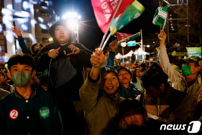 라이칭더 민진당 총통 후보가 당선을 확정지은 13일(현지시간) 밤 지지자들이 대만 타이베이의 거리로 나와 깃발을 흔들며 승리를 기념하고 있다. 2024.01.13 ⓒ 로이터=뉴스1 ⓒ News1 정지윤 기자
