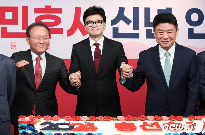 한동훈 국민의힘 비상대책위원장(가운데), 윤재옥 원내대표, 유의동 정책위의장이 1일 오전 서울 여의도 국민의힘 중앙당사에서 열린 2024년 신년인사회에서 손을 맞잡고 있다. 2024.1.1/뉴스1 ⓒ News1 임세영 기자