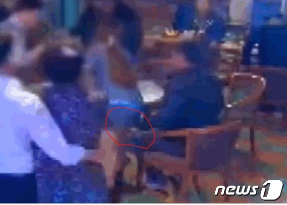 지난해 12월 전북 익산의 한 술집에서 한 남성이 여 직원 치마속에 손(붉은 원)을 집어 넣고 있다. (jtbc  갈무리) ⓒ 뉴스1
