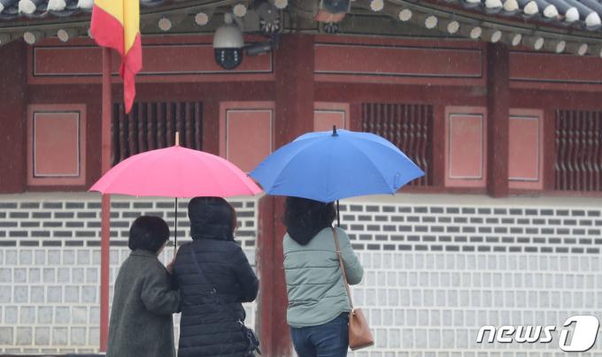 17일 경기 수원시 팔달구 화성행궁 광장에서 시민들이 싸리눈을 피해 우산을 쓰고 걷고 있다. 2023.1.17/뉴스1 ⓒ News1 김영운 기자