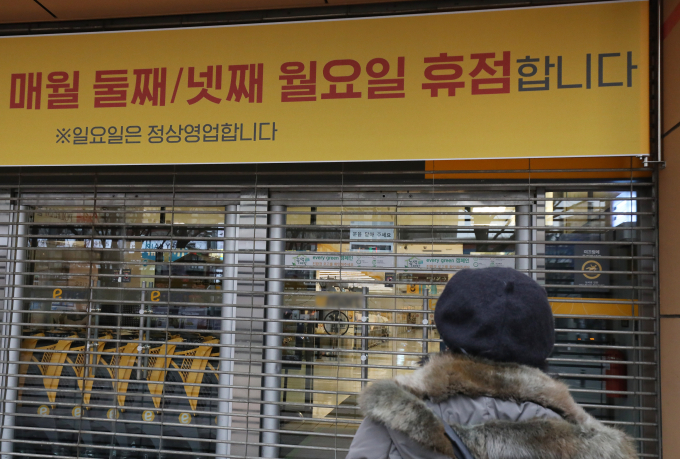 대구 지역의 대형마트 의무휴업일이 일요일에서 평일인 월요일로 변경된 지난해 1월13일 오후 휴점에 들어간 대구 수성구 한 대형마트 출입문이 닫혀 있다. 휴업일 변경을 모른 채 장을 보기 위해 마트를 찾은 한 시민이 문 닫은 마트 내부를 바라보고 있다./사진=뉴스1