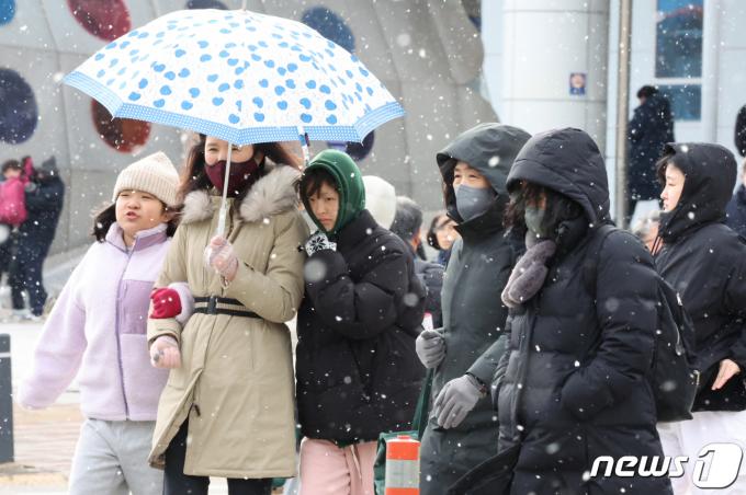 광주와 전남 7개 시군(나주·목포·영암·무안·함평·장성·영광)에 대설주의보가 내려진 22일 오후 광주시 광산구 송정역앞에서 시민들이 눈을 맞으며 걷고 있다.2024.1.22/뉴스1 ⓒ News1 김태성 기자