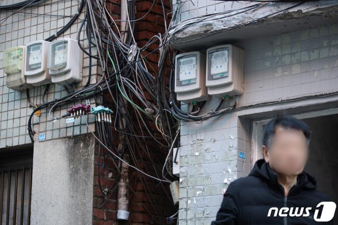 16일 서울시내 한 쪽방촌에 설치된 전력량계 앞으로 시민이 지나고 있다.  ⓒ News1 유승관 기자