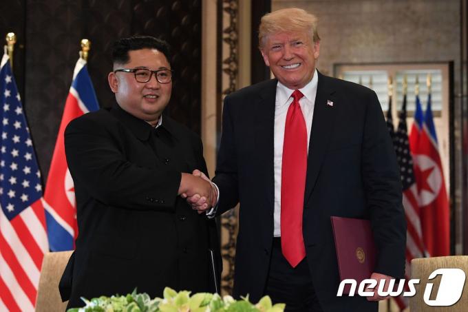 김정은 북한 국무위원장과 도널드 트럼프 미국 대통령이 12일(현지시간) 싱가포르 센토사 섬 카펠라 호텔에서 140여 분에 걸친 단독·확대정상회담과 업무오찬을 마친 뒤 북미정상회담 공동합의문에 서명 후 악수를 하고 있다. ⓒ AFP=뉴스1 ⓒ News1 우동명 기자