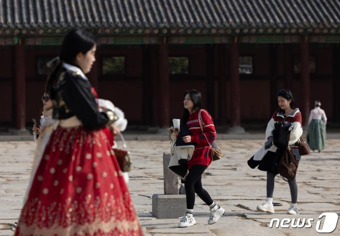 서울 낮기온이 6도까지 오르며 포근한 겨울 날씨를 보인 2일 오후 서울 종로구 경복궁을 찾은 외국인 관광객들이 외투를 손에 들고 발걸음을 옮기고 있다. 2024.2.2/뉴스1 ⓒ News1 이재명 기자