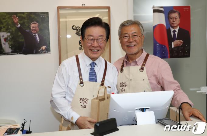 이재명 더불어민주당 대표가 지난해 5월10일 오후 문재인 전 대통령이 최근 경남 양산 평산마을에 문을 연 평산책방을 찾아 계산대에서 봉사를 마친 뒤 기념사진을 찍고 있다. (공동취재)/뉴스1 ⓒ News1 윤일지