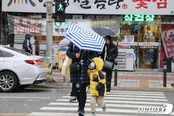 22일 오전 광주 동구 금남로5가역 버스정류장 일대에서 두꺼운 옷을 입고 우산을 쓴 시민들이 발걸음을 옮기고 있다. 2024.1.22/뉴스1 ⓒ News1 박지현 수습기자