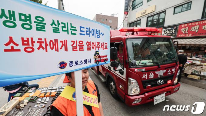 서울종로소방서 대원들과 종로 의용소방대원들이 서울 종로구 동묘 벼룩시장에서 재난대응 안전한국훈련의 일환으로 소방차 길터주기 훈련을 하고 있다. 2023.11.1/뉴스1 ⓒ News1 김도우 기자