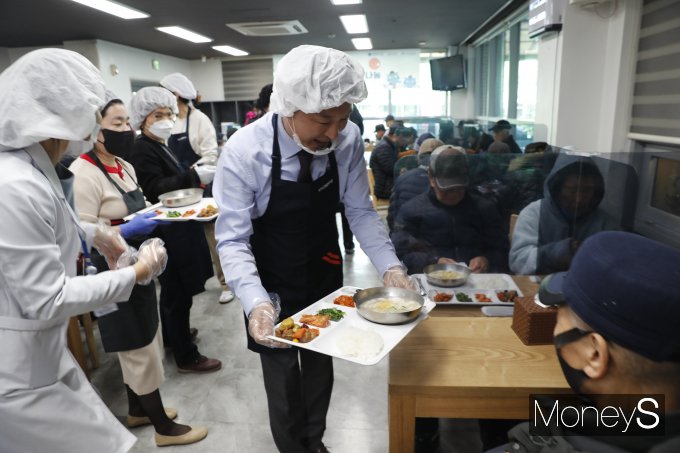 이동훈 광주신세계 대표가 7일 광주 서구노인종합복지관 경로 식당에서 김이강 광주서구청장 등과 함께 무료 점심 배식 봉사활동을 하고 있다/사진=광주신세계 제공.