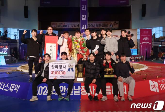 11일 충남 태안군 태안종합실내체육관에서 열린 '위더스제약 2024 태안설날장사씨름대회'에서 한라장사(105kg이하)에 등극한 김보경(문경시청)이 김선곤 감독을 비롯한 코치진 및 동료 선수들과 함께 기념촬영을 하고 있다.(대한씨름협회 제공) 2024.2.11/뉴스1 ⓒ News1 민경석 기자