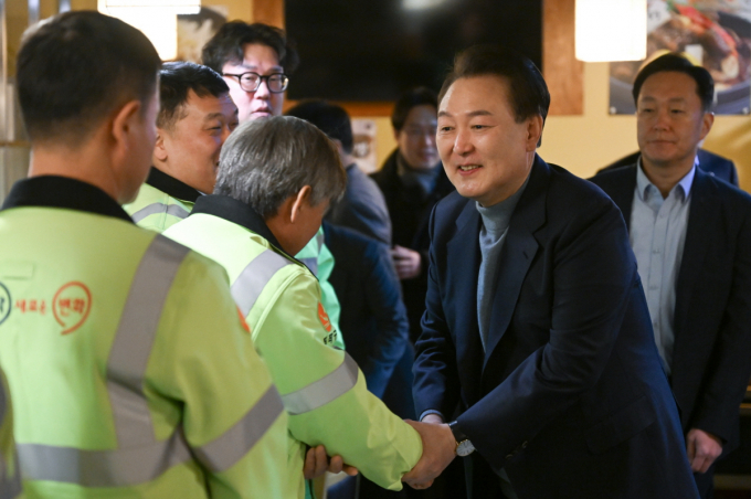 윤석열 대통령이 설 연휴 첫날인 9일 서울 동작구의 한 식당에서 열린 환경공무관들과의 떡국 조찬에 참석해 참석자들과 악수를 나누고 있다. /사진=뉴스1