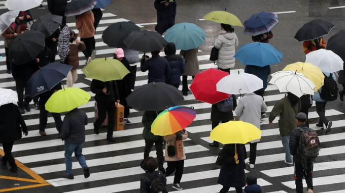 14일 낮 기온이 최고 19도까지 올라가면서 전국적으로 맑은 날씨가 예상된다. 남부지방에서는 비가 내려 충청 이남까지 확대될 전망이다. 사진은 지난 5일 오후 부산 동래구 도시철도 동래역 앞에서 우산을 쓴 시민들이 발걸음을 재촉하는 모습. /사진=뉴스1
