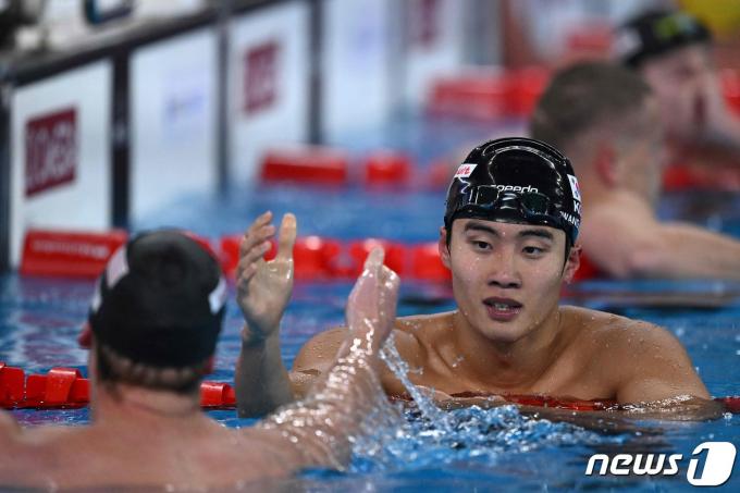 황선우가 13일 오후(현지시간) 카타르 도하 어스파이어돔에서 열린 2024 세계수영선수권대회 경영 남자 자유형 200m 결승에서 우승을 확정지은 후 미국의 루크 홉슨의 축하를 받고 있다. ⓒ AFP=뉴스1 ⓒ News1 안은나 기자