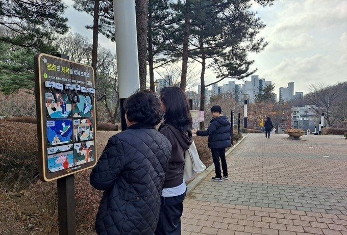 안양시 만안구 구민들이 충훈공원 내에 조성된 백세행복길에서 안내판을 살펴보고 있다. / 사진제공=안양시