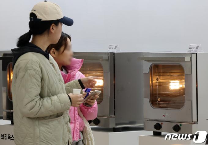 [사진] 베이커리 기기 살펴보는 관람객들