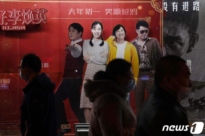 베이징 한 영화관 앞에서 시민들이 '니하오, 리환잉', 전광판 앞을 지나가고 있다. 2021.2.22 ⓒ AFP=뉴스1 ⓒ News1 정은지 특파원