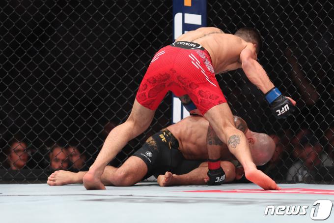 UFC 페더급 챔피언 알렉산더 볼카노프스키(아래)가 도전자 일리야 토푸리아에게 펀치를 맞고 쓰러지고 있다. ⓒ AFP=뉴스1