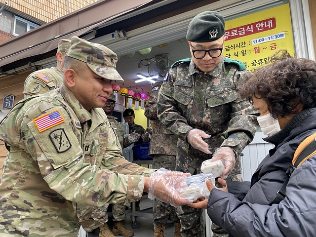 홍선준 육군 50사단 대위를 비롯한 군 관계자들이 美 USAG-D 장병들과 음식나눔 봉사활동을 하고 있다./사진제공=육군 제50보병사단