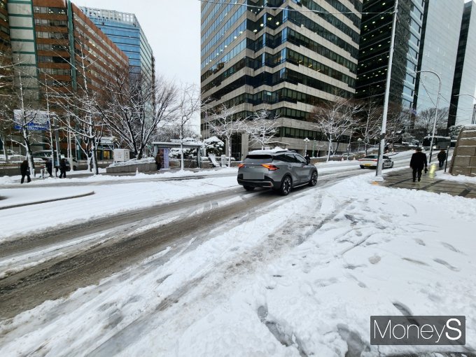 지난 21일 내린 눈이 쌓였지만 제설작업이 바로 이뤄지지 않아 시민들의 불편함이 속출했다. 사진은 22일 눈 내린 서울 중구 광화문 광장 도로를 달리는 자동차의 모습. /사진=박찬규 기자