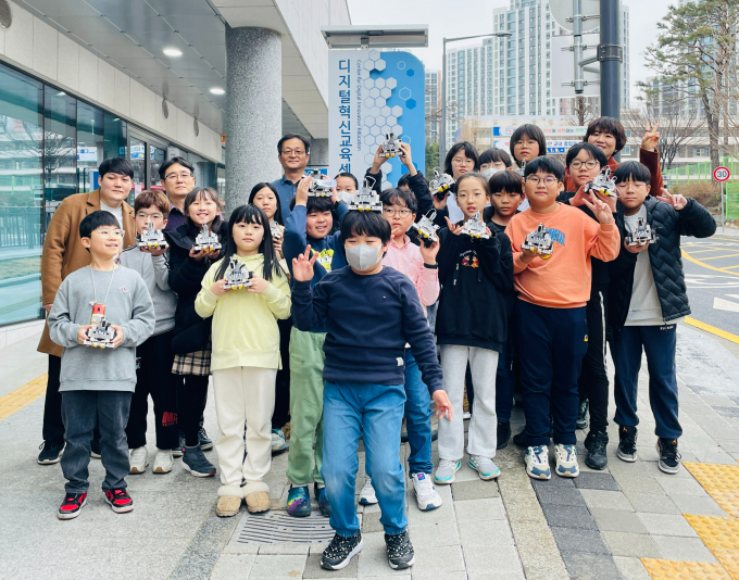 광명시디지털혁신교육센터에서 실시한   ‘AI 자율주행 코딩’에 참가한 초·중학생들이 프로그램 과정에서 만든 결과물을 들고 기뻐하고 있다./ 사진제공=광명시
