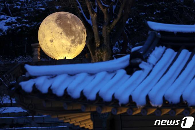 [사진] 눈 덮힌 처마 위로 떠오른 보름달