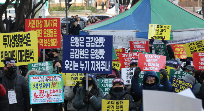 홍콩 H지수(항셍중국기업지수) 기초 주가연계증권(ELS) 피해자모임이 지난달 19일 오후 서울 영등포구 여의도 금융감독원 앞에서 손팻말을 들고 보상을 촉구하는 모습./사진=뉴스1