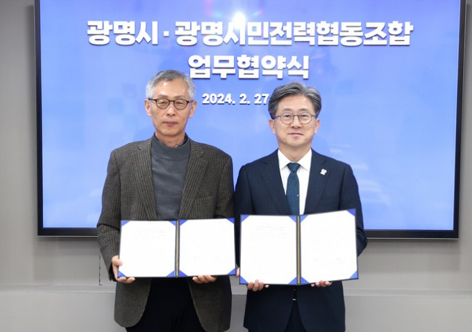 정순욱 광명시 부시장(오른쪽)이 27일 오전 광명시청에서 전형근 광명시민전력협동조합 이사장(왼쪽)과 재생에너지 보급과 기금 조성을 위한 업무협약을 체결한 뒤 포즈를 취하고 있다./  사진제공=광명시