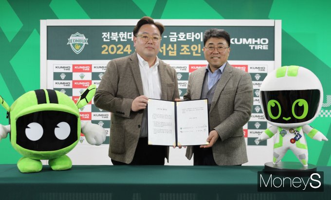 윤장혁 금호타이어 G.마케팅담당 상무(오른쪽)와 이도현 전북현대모터스 단장이 공식 파트너십 조인식을 갖고 사진 촬영을 하고 있다/사진=금호타이어 제공.
